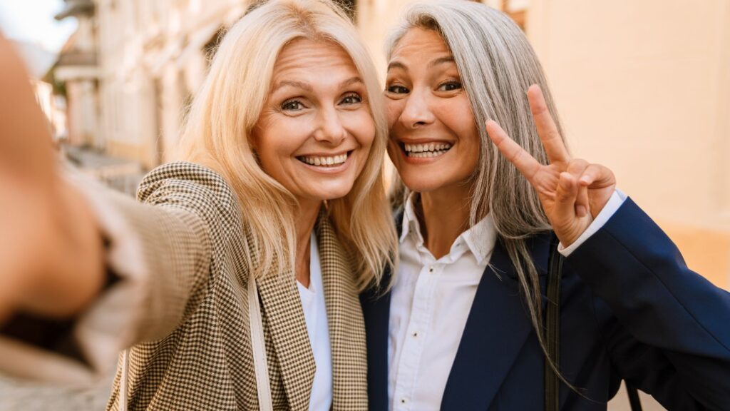 Dojrzałe kobiety pozują do zdjęcia na mieście.