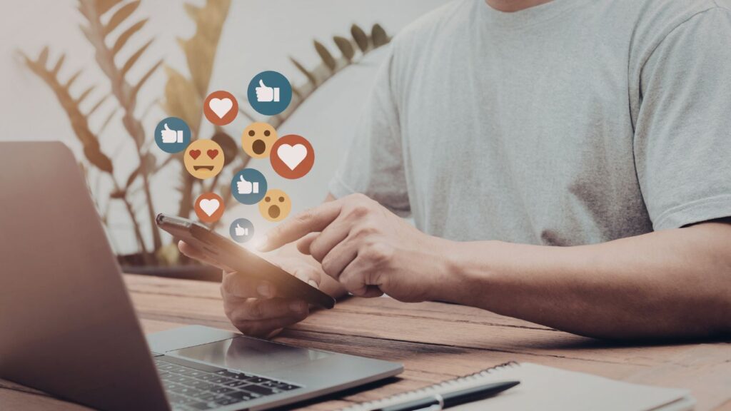 Mężczyzna próbuje uploadować zdjęcie z telefonu na komputer i na social media.