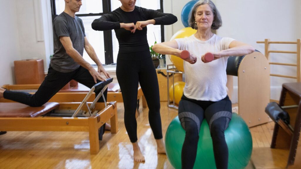 Kobieta podczas wizyty na siłowni ćwiczy równowagę i koordynację.