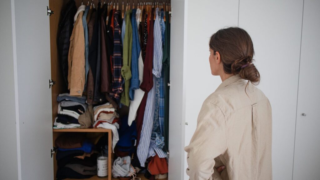 Kobieta posiada bardzo głęboką szafę i zastanawia się, jak w niej poukładać ubrania.