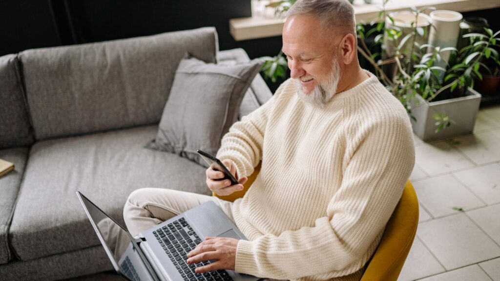 Mężczyzna łączy telefon z komputerem bez użycia kabli.
