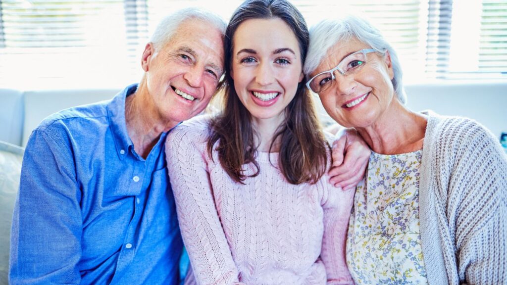 Uśmiechnięta córka siedzi wraz ze swoimi rodzicami.